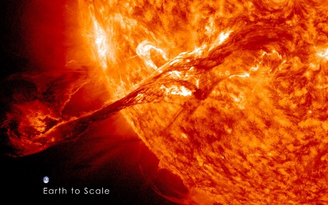 A coronal mass ejection (left) with the Earth to scale. Image courtesy NASA Solar Dynamics Observatory